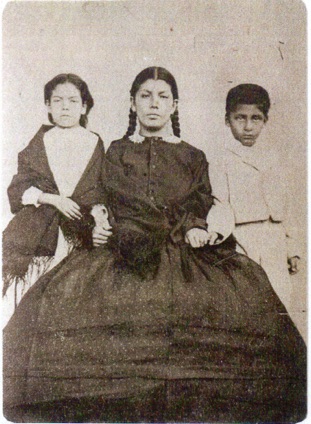 Josefa Valenzuela with children. Her son, Jose Dolores Frias on the right. Uruachic, Chihuahua, Mexico, 1873.
